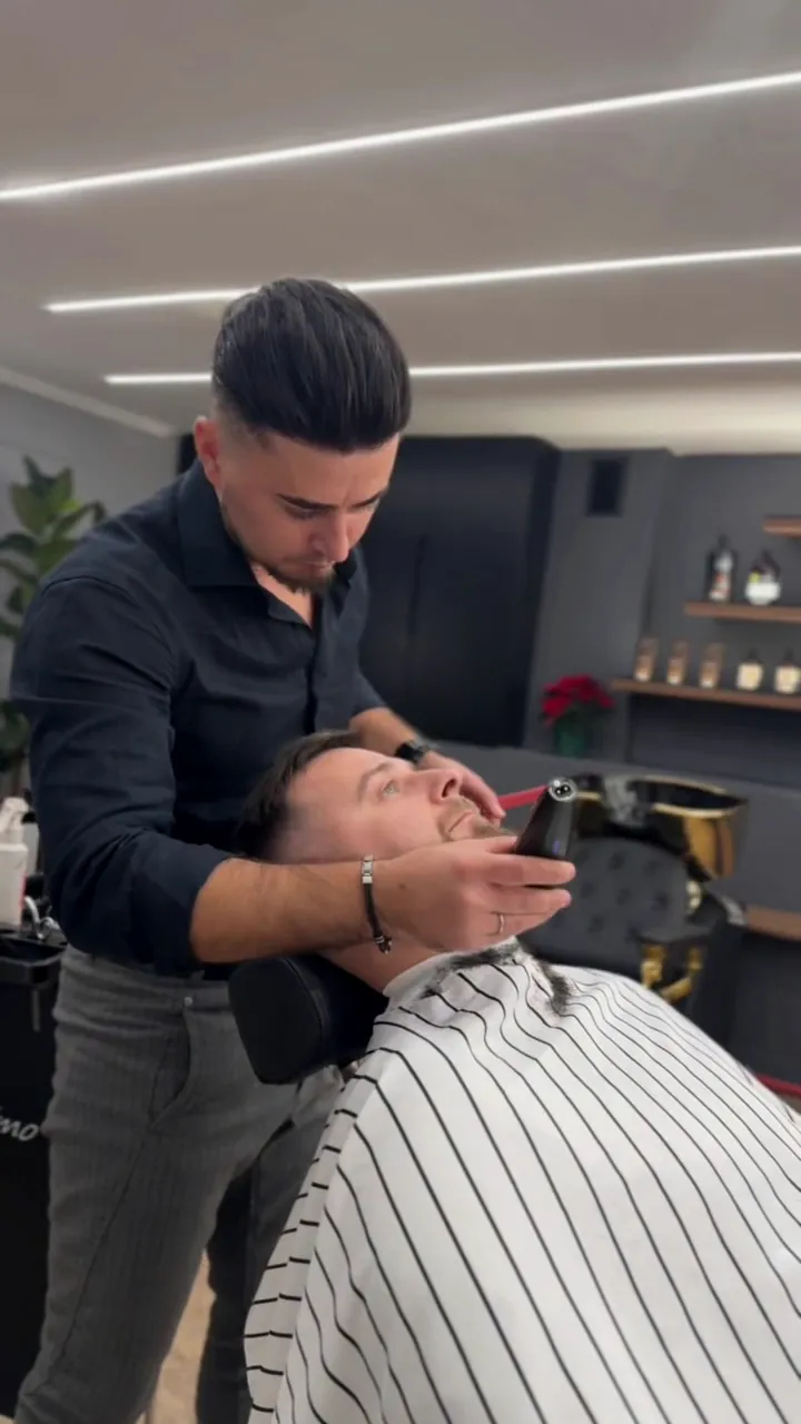 Barber podczas precyzyjnego wykańczania zarostu klienta